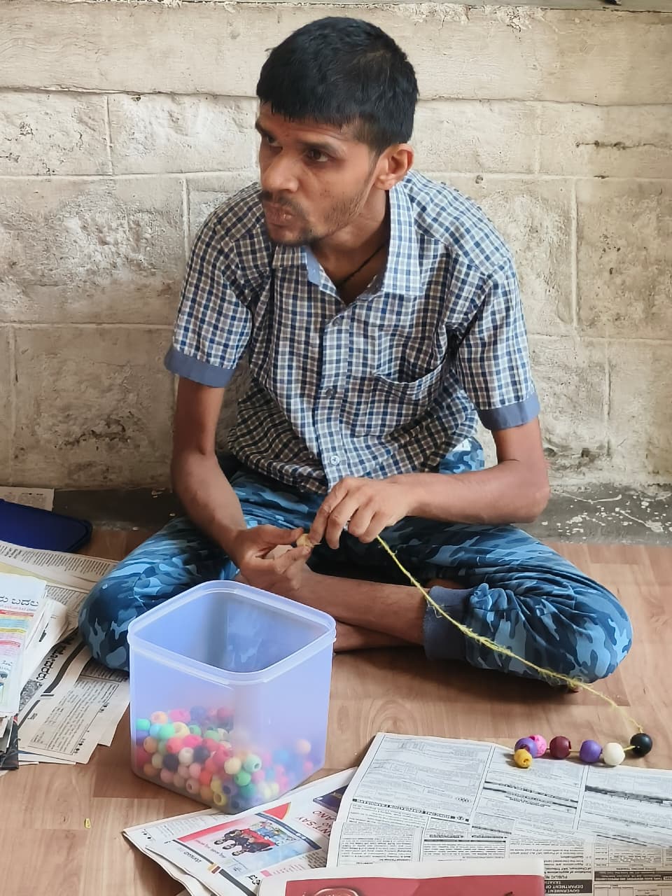 Student stringing large colourful beads during a classroom activity